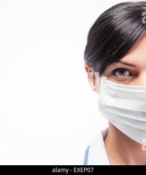 Portrait d'une femme médecin dans le masque à l'écart isolé sur fond blanc Banque D'Images