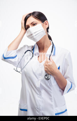 Portrait de femme médecin en masque ayant des maux de tête sur fond blanc Banque D'Images