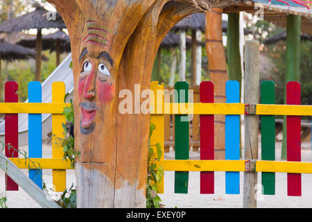 Tronc de l'arbre si enfantine décorée d'un visage dans un parc Banque D'Images