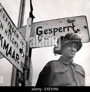 Cette photographie capture un véhicule militaire, probablement un véhicule de l'armée américaine, positionné près d'un panneau routier allemand pendant la seconde Guerre mondiale. La scène représente le mouvement des forces alliées en Europe pendant la guerre, en se concentrant sur l'avion Liberator. Banque D'Images