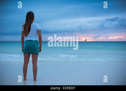 Vue arrière du jeune femme regardant la mer au coucher du soleil, l'île de Boracay, Visayas, Philippines Banque D'Images