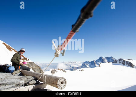 Manger des collations Male hiker sur l'affichage de la plate-forme, Jungfrauchjoch, Grindelwald, Suisse Banque D'Images