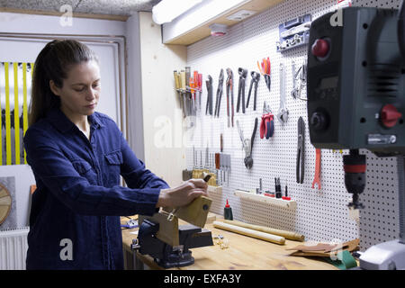 Young female carpenter panneaux en bois vice-atelier Banque D'Images