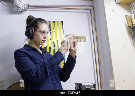 Young female carpenter contrôle en atelier bois Banque D'Images