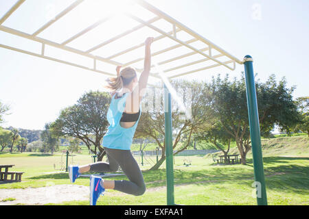 Femme de la formation dans le parc monkey bars Banque D'Images