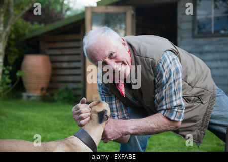 Man, caresser le chien dans le jardin Banque D'Images