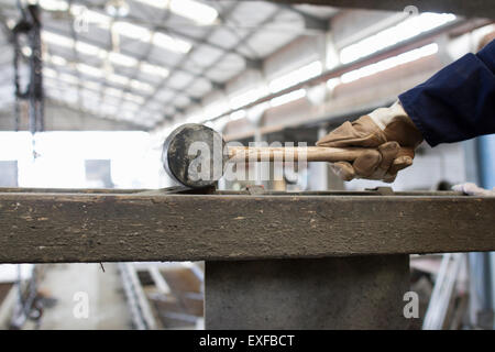 Les travailleurs de l'usine de pair avec marteau en caoutchouc dans le renforcement du béton factory Banque D'Images