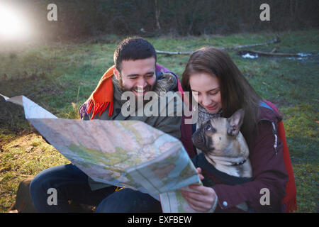 Randonnée jeune couple reading map in woods Banque D'Images