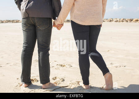 Cropped vue arrière du jeune couple pieds nus sur la plage, à Tel Aviv, Israël Banque D'Images