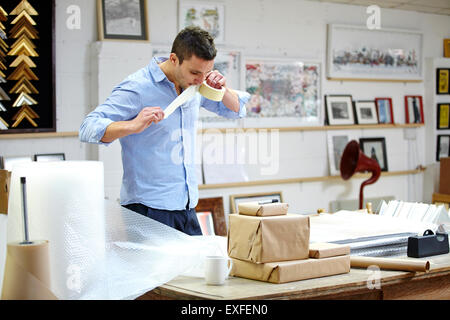 Emballage bulle homme cadre sur table dans les encadreurs atelier Banque D'Images