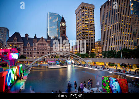 TORONTO,CANADA-Juillet 9,2015 : Le nouveau signe de Toronto au Nathan Phillips Square, hôte de PanaMania, un contant fête célébrant les jeux PanAm. L'ancien hôtel de ville et le centre-ville de bâtiments à l'arrière. Banque D'Images