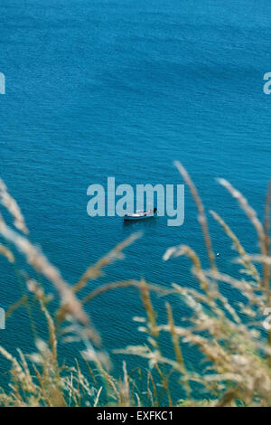 Bateau de pêche isolés mouillant au large d'église Cove, lézard, Cornwall, UK, du chemin côtier du sud-ouest Banque D'Images