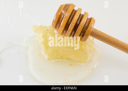 De miel avec du miel et une cuillère de balancier sur fond blanc Banque D'Images