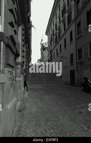 La photographie de rue en noir et blanc image d'une rue latérale à Rome et quelques mesures avec un homme à directement à l'appareil photo Banque D'Images