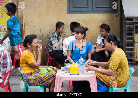 Yangon, Myanmar-May 5e 2014 : Les gens assis à un café de la rue. Il s'agit d'une activité traditionnelle avant de commencer le travail. Banque D'Images