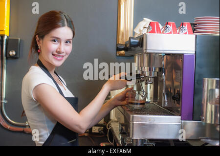 Female bartender fait du café à l'aide d'une machine à café. Banque D'Images
