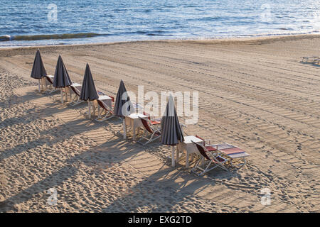 Fermé de parasols et chaises longues, des chaises vides et des chaises longues, avec aucun peuple Banque D'Images