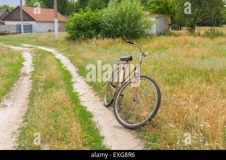 Vieux vélo rouillé attendent le maître sur la route Banque D'Images