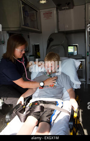 Female paramedic aider les jeunes patients de sexe masculin à l'arrière de l'ambulance. Banque D'Images