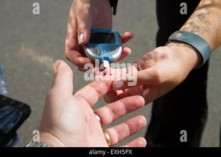 / EMT Paramedic administre le test de sucre de sang en ambulance. Banque D'Images