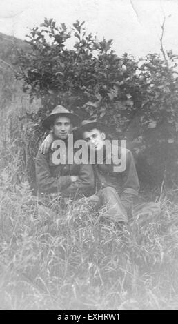 Cette photographie historique du camp Funston montre deux hommes assis sur une colline, reflétant un moment de la vie militaire de la première Guerre mondiale, capturant la vie quotidienne des soldats dans les camps d'entraînement. Banque D'Images