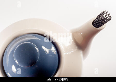 Théière blanc céramique avec ornement fleur bleu sur fond blanc Banque D'Images