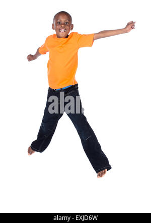 Cute african boy portant un tee-shirt orange et jeans en denim foncé. Le garçon saute et souriant. Banque D'Images