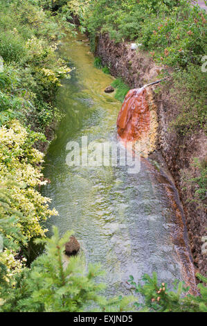 Un printemps de l'eau riche en minéraux des roches de coloration à la ville thermale de Châtel-Guyon, Puy-de-Dôme, Auvergne, France, Europe Banque D'Images