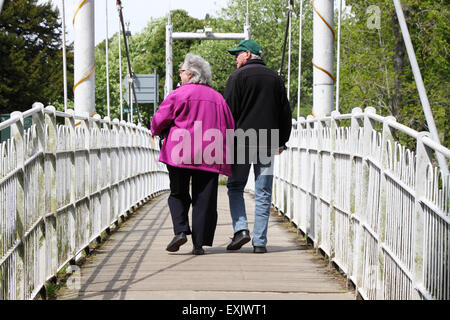 Couple dans la cinquantaine ou soixantaine traversant l'Infirmerie Pont sur la rivière Ness, Inverness, Scotland Banque D'Images