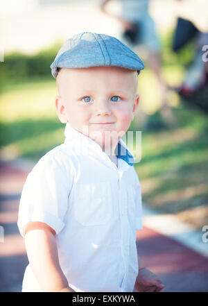 Cute little boy dans un bouchon sur le fond de la nature Banque D'Images