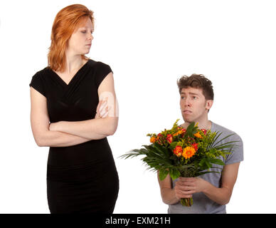 Jeune garçon offrant un bouquet de fleurs à sa petite amie en colère Banque D'Images