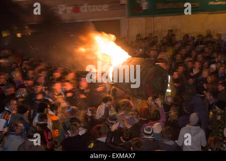 Grand men's barrel en cours au travers des foules sur la place pour marquer le Bonfire Night, 5 novembre, à la tar de barils festival, Honiton, Devon, Angleterre Banque D'Images