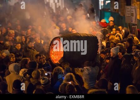 Grand men's barrel en cours au travers des foules sur la place pour marquer le Bonfire Night, 5 novembre, à la tar de barils festival, Honiton, Devon, Angleterre Banque D'Images