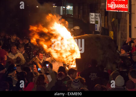 Grand men's barrel en cours au travers des foules sur la place pour marquer le Bonfire Night, 5 novembre, à la tar de barils festival, Honiton, Devon, Angleterre Banque D'Images