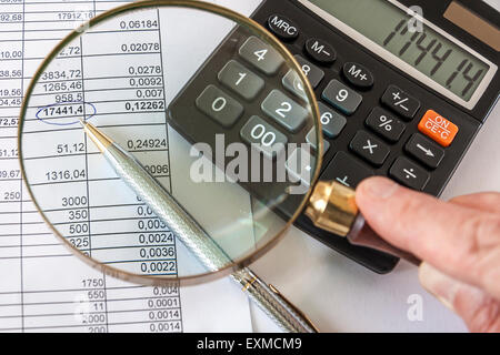 Main tenant Loupe pour contrôle de document d'entreprise Banque D'Images