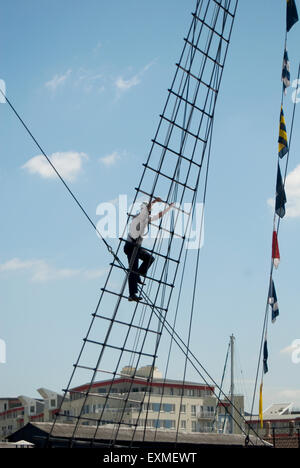 L'homme d'affaires l'escalade les gréements à bord SS Great Britain amarré à Bristol - habillé en chemise blanche et pantalon noir Banque D'Images