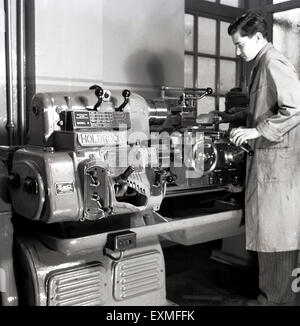 Années 1950, photo historique montrant un jeune homme adulte utilisant une machine à usiner de précision, un tour de banc mécanique fabriqué par la Holbrook machine Tool Co, une société britannique fondée en 1850. En 1917, elle a commencé à fabriquer des tours à moteur autonomes et a ensuite fabriqué des tours de chasse optique de précision, dont une grande version est vue sur l'image. Banque D'Images