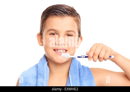 Petit garçon se brosser les dents avec une brosse à dents et regardant la caméra isolé sur fond blanc Banque D'Images