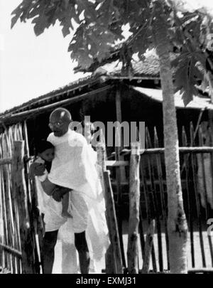 Mahatma Gandhi portant l'enfant de Shardabehn à Seagram Ashram ; 1940, Inde, Asie, ancienne image du millésime 1900 Banque D'Images