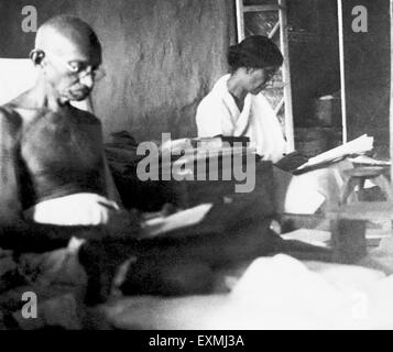 Mahatma Gandhi assis dans sa cabane de Ashram Sevagram ; 1938 ; à côté de lui Rajkumari Amrit Kaur PAS MR Banque D'Images