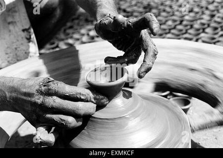 Un potter s'assied sur son tour de potier qu'il fait diyas fait d'argile pour le festival du Diwali dans Kumbhaewada ; Mumbai Dharavi Banque D'Images