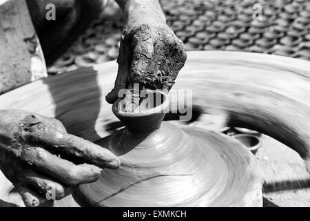 Un potter s'assied sur son tour de potier qu'il fait diyas fait d'argile pour le festival du Diwali dans Kumbhaewada ; Mumbai Dharavi Banque D'Images