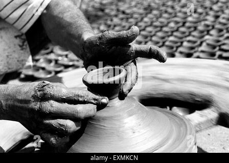 Un potter s'assied sur son tour de potier qu'il fait diyas fait d'argile pour le festival du Diwali dans Kumbhaewada ; Mumbai Dharavi Banque D'Images