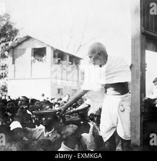 Mahatma Gandhi ; recueillir des dons pour financer Harijan avec un panier à la main dans une gare sur le chemin de l'Assam Banque D'Images