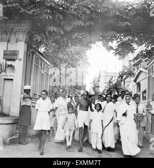 Mahatma Gandhi ; accompagné d'autres personnes ; sur son chemin à une réunion de prière à partir de la Birla House à Rungta Maison , Mumbai Banque D'Images