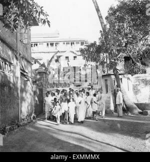 Mahatma Gandhi et d'autres marchant sur l'enceinte de la Birla House après avoir terminé la prière à Rungta Maison , Mumbai Banque D'Images