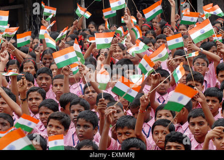 Les enfants de l'école de célébrer le Jour de l'indépendance indienne en brandissant le drapeau indien couleur tri dans Bombay Mumbai Maharashtra ; Inde ; Banque D'Images