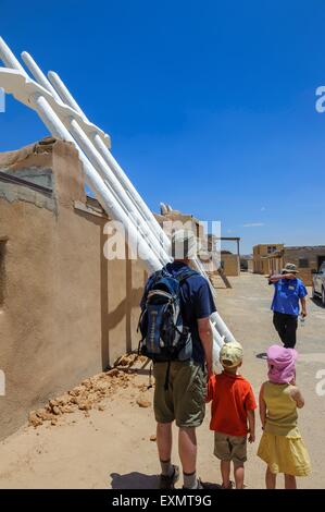 Guide touristique à côté de l'échelle en bois menant à l'entrée d'une kiva. Acoma Pueblo. Cibola County, Nouveau Mexique, USA Banque D'Images