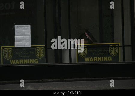 Londres, Royaume-Uni, le 15 juillet, 2015. Les agents travaillent à l'intérieur de l'adresse - à gauche, une mise par les squatters précédent peut être vu sur le non-résidentiel de l'immeuble - Ville de Londres policiers assister à un appel de travailleurs municipaux au sujet d'un possible cambriolage au 1-7 Leadenhall Street, EC3 à Londres le 15 juillet 2015. Contient des agents des sorties à l'adresse et préparé des torches et le port sur le corps-caméras avant de mener une recherche approfondie dans les locaux, qui s'est avéré être vide. Credit : Finn Nocher/Alamy Live News Banque D'Images