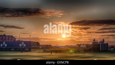 St Andrews, Fife, Scotland, UK. 15 juillet, 2015. Coucher de soleil sur l'ancien cours, St Andrews comme greenkeepers faire leurs vérifications finales sur l'allée du 18e trou. Le Old Course Hotel est affiché derrière les stands. Credit : Kirsty Robson/Alamy Live News Banque D'Images